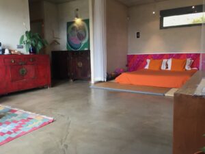 Habitación Grande de Hotel La Canela, con cama amplia, decoración asiática y mueble rojo artesanal.